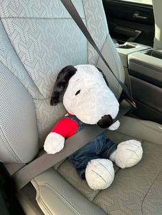 a stuffed dog sitting in the back seat of a car with its head hanging out