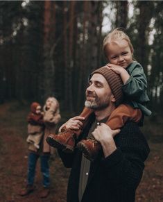 a man holding a child in the woods