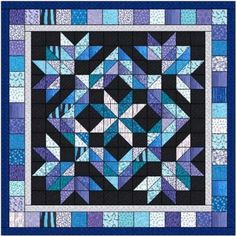 a blue and black quilt with an intricate design on the front, featuring several triangles