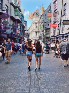 two women walking down the middle of a street