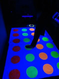 a person standing on top of a glowing floor with colorful dots in the middle of it