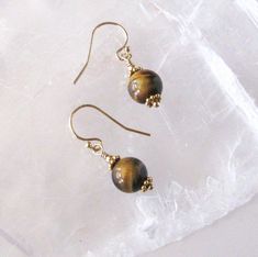 "These drop earrings feature a pair of pretty Tiger Eye gemstone beads which I've accented with tiny gold beads and other goldfilled  findings. Shown with goldfilled hooks, you may also choose other ear wire options. This pair of beads has a glossy, rich coffee brown background with iridescent, shimmering golden yellow bands that gently spiral around the beads along with some larger areas of gold chatoyance as they move and turn. ~The round Tiger Eye gemstone beads are 8mm size, 5/16 inch. ~The Everyday Gold Round Beaded Earrings, Gold Beaded Earrings With French Hook As Gift, Gold Hypoallergenic Earrings, Gold Round Beads Earrings For Everyday, Everyday Gold Round Bead Earrings, Gold Hypoallergenic Earrings With Round Beads, Adjustable Gold Beaded Earrings, Gold Beaded Dangle Earrings With French Hook, Gold Jewelry With French Hook And Round Beads