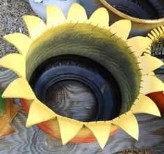 a sunflower shaped vase sitting on top of a wooden table next to other items