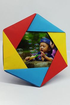 a multicolored cube with an image of a child blowing bubbles