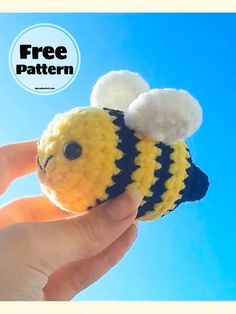 a hand holding a small crocheted bee