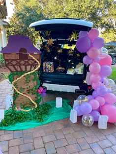 the trunk of a car is decorated with balloons and streamers