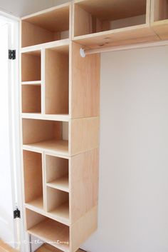 an empty closet with wooden shelves and white walls