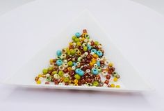 a white plate topped with lots of colorful beads