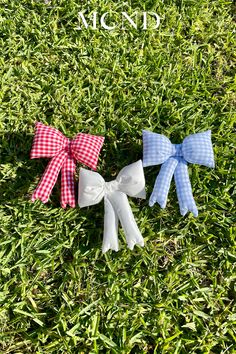 three bows are laying in the grass together