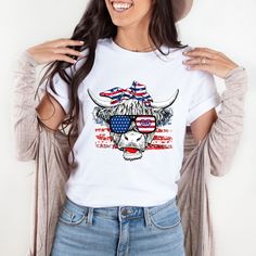 Women's Patriotic Shirt, July 4th Shirt, 4th of July T-Shirt, Cow Shirt, American Flag Shirt, Cute Mom Tee, Funny Patriotic Shirt, USA This adorable cow patriotic shirt. This funny cow shirt is perfect for Independence Day. You've now found the staple t-shirt of your wardrobe. It's made of 100% ring-spun cotton and is soft and comfy.  * 100% ring-spun cotton    Size: S - 3XL White Americana T-shirt For 4th Of July, American Style White Tops For 4th Of July, White Americana T-shirt With American Flag, White Americana T-shirt For Summer, White Americana Style Summer T-shirt, White Graphic Tee With American Flag, White Americana T-shirt With American Flag Print, White American Flag Relaxed Fit Top, White American Flag Top With Relaxed Fit