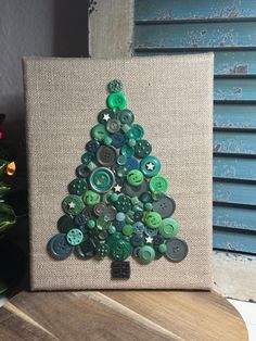 a christmas tree made out of buttons on a canvas