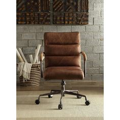 a brown office chair sitting in front of a brick wall