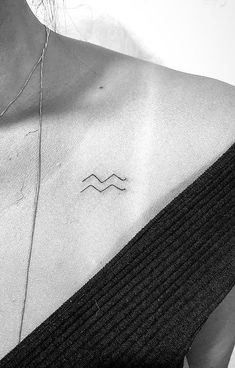 a woman's chest with a small wave tattoo on the left side of her neck