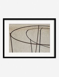 an abstract photograph with black frame on the wall above it is a circular metal object