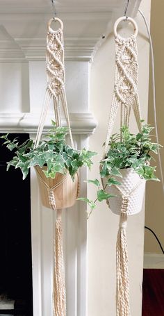 two macrame plant hangers with plants in them hanging from the side of a fireplace