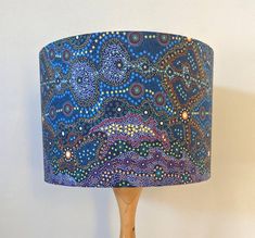 a wooden table lamp with a blue and purple lampshade sitting on top of it