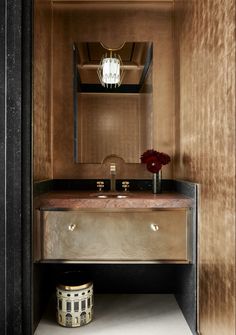 a bathroom with a sink, mirror and lights in the corner on the wall above it