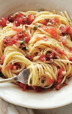 a white bowl filled with pasta and tomatoes