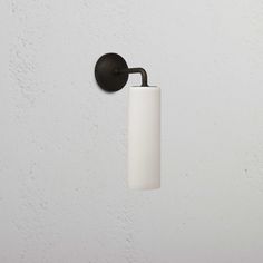 a black and white toilet paper dispenser hanging from a hook on a wall