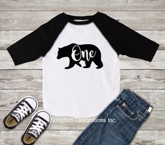 *Bear "One" 1st Birthday Shirt* This adorable bear shirt is so fun for a 1st Birthday celebration. 100% cotton. Made with a black and white raglan shirt with black font. Runs true to size. For an extra special touch have the back personalized with the birthday boy's name and a "1", jersey style. See pictures for an example. All my shirts are made using high quality heat transfer vinyl and professional heat press equipment. Vinyl will not peel or fade. Made to last, wear after adorable wear:) SHI First Birthday Boy Shirt, 1st Birthday Wild One, Birthday Wild One, First Birthday Boy, Birthday Boy Shirt, Boho Flower Girl, 1st Birthday Shirts, Flower Girl Headbands, Birthday Boy Shirts