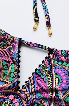 The Disco Dream foil print brings the party with its vibrant paisley pattern, swirling in shades of bright violet, pink, green, and black. This midkini top features adjustable spaghetti straps, pom-pom trim, and a flirty keyhole front. Gold lantern charms complete the look. [split] Details Midkini top Pom-pom trim Removable cups Adjustable straps Neck tie w/ gold lantern charms Coordinates with black, bright violet & seaglass Fabric 83% Nylon, 17% Lycra Elastane Midkini Tops, Gold Lanterns, One Piece Top, Pom Pom Trim, Green And Black, Foil Print, Paisley Pattern, Neck Tie, Adjustable Straps