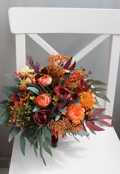 a bouquet of flowers sitting on top of a white chair