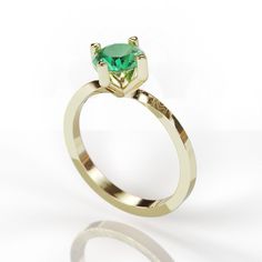 a gold ring with a green stone in the center