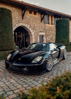 a black sports car parked in front of a house