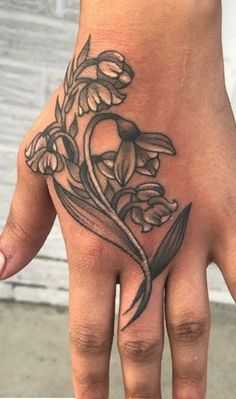 a hand with a flower tattoo on it