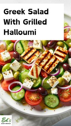 greek salad with grilled hallouni and olives on a white platter