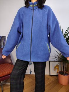 a woman wearing a blue jacket and black pants