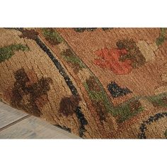 a close up of a rug on the ground with wood flooring in the background