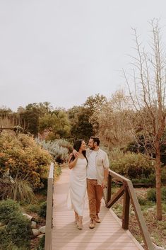 a man and woman are walking on a bridge