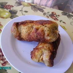 two pieces of meat sitting on top of a white plate