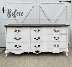 a white dresser with black top and drawers in front of a barn door that says before