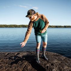 a man standing on top of a rock near the water