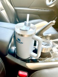 a cup with a straw in it sitting on the center console of a car