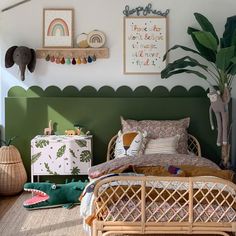 a bedroom decorated in green and white with plants on the wall, bedding and rugs