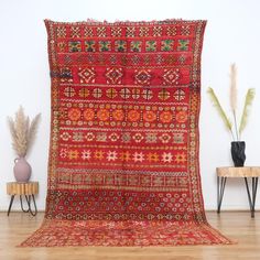 an old rug is displayed in front of a white wall