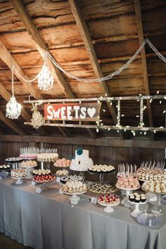 a table topped with lots of cupcakes next to a sign that says sweet