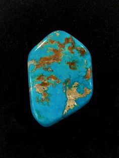 a piece of turquoise and gold colored stone