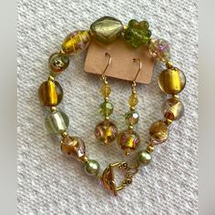 Handmade Bracelet And Earring Set. Beautiful Green And Gold Tones. Some Glass Lamp Work And Wedding Cake Beads Are Refurbished From Broken Jewelry. The Gold Tone Spacers Are New As Well As New Earring Lever Back Hooks That Are Stainless Steel Hypoallergenic And Gold Tone. New Toggle Clasp As Well With Nice Details. Earrings Approximately 2” Long. Bracelet Fits 6.5” Wrists To 7-1/2” Long. (I’m A 6” And It’s A Bit Too Big On Me But Does Not Fall Off). Long Bracelet, Bracelet And Earring Set, Bead Set, Handmade Bracelet, Toggle Clasp, Glass Lamp, Handmade Bracelets, Green And Gold, Wedding Cake