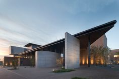 an architecturally designed building lit up at night with lights on the outside and inside