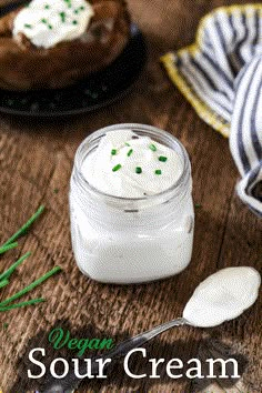 a jar of whipped cream sitting on top of a wooden table next to a spoon