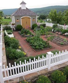 a white picket fence surrounding a garden area