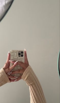 a woman taking a selfie with her cell phone in front of the camera mirror