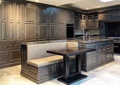 a kitchen with granite counter tops and dark wood cabinetry, along with a breakfast nook