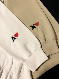 two white sweatshirts with red hearts on them and the letters i love aa written in black