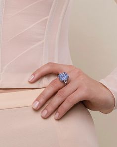 a woman's hand wearing a ring with an aqua blue topazte on it