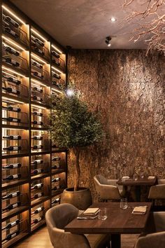 a wine cellar with wooden tables and chairs in front of a wall full of bottles